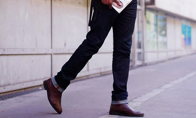 A photo of a man wearing dark jeans. 
