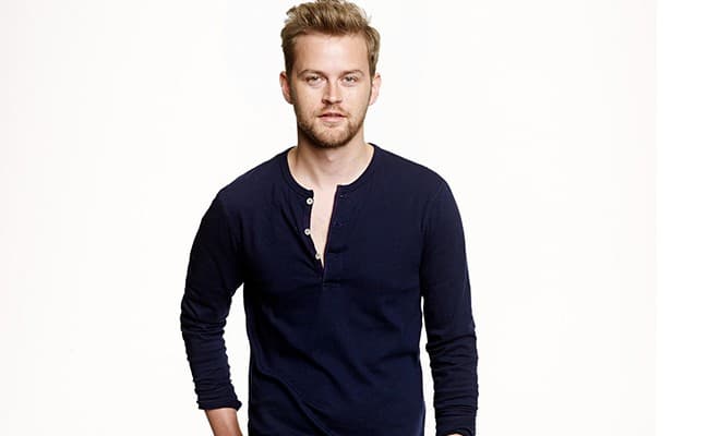 A photo of a guy wearing a henley shirt, which is men's fashion essential. 